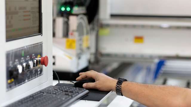 Hånd styrer computermus ved maskinstyring