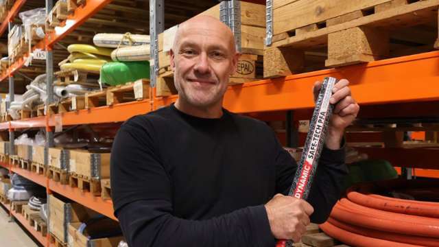 Mand som holder en industrislange på lager